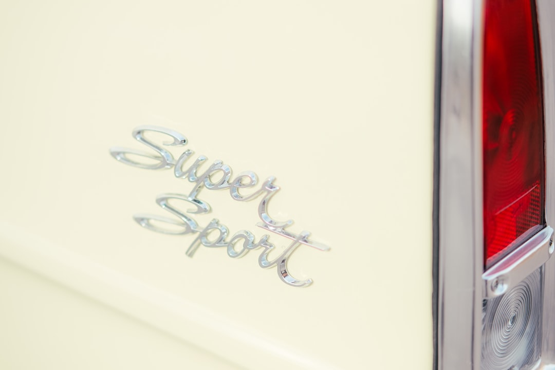 Chrome "super sport" emblem on a cream car.