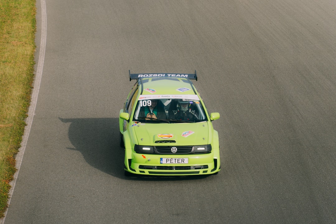 A green car driving down a race track