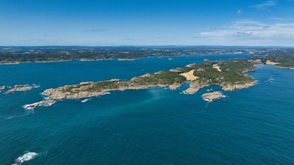 Aerial view of a rocky island coastline with blue ocean.