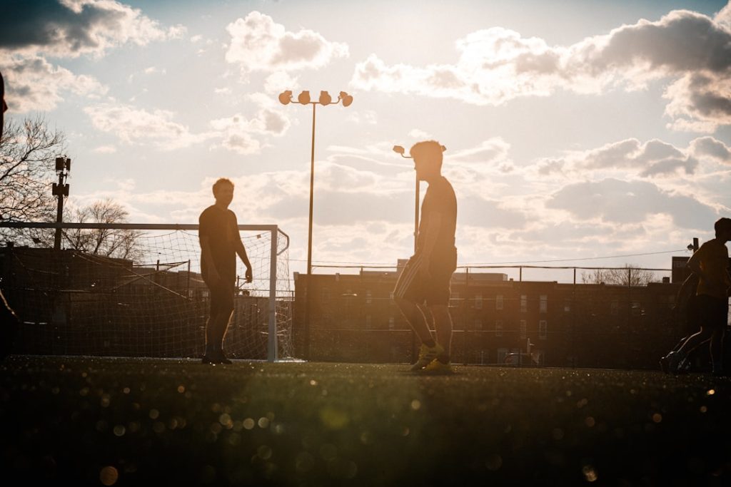 a couple of men standing on top of a soccer field