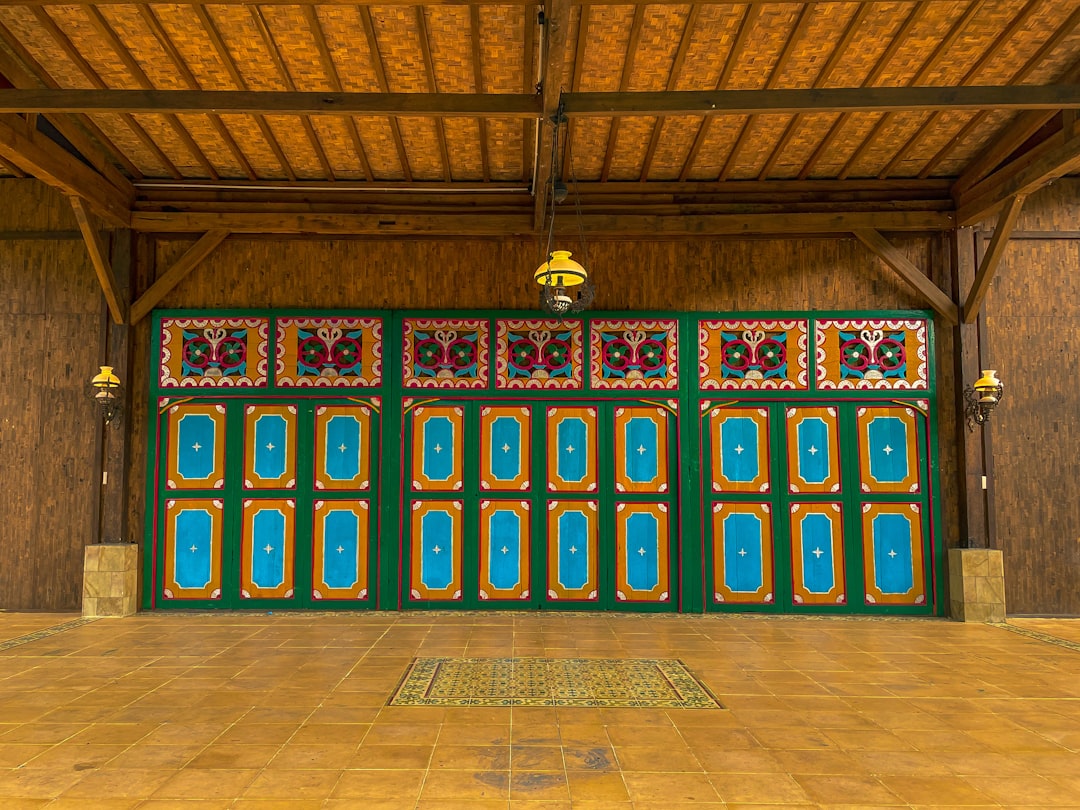 a room with a large wooden door and tiled floor