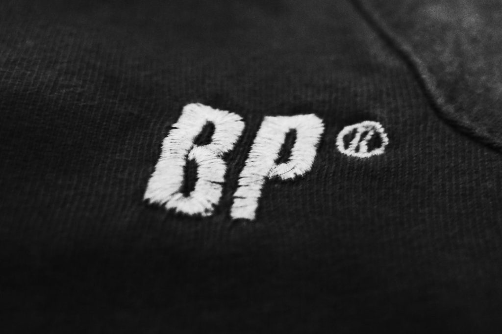 White embroidered bp logo on dark fabric