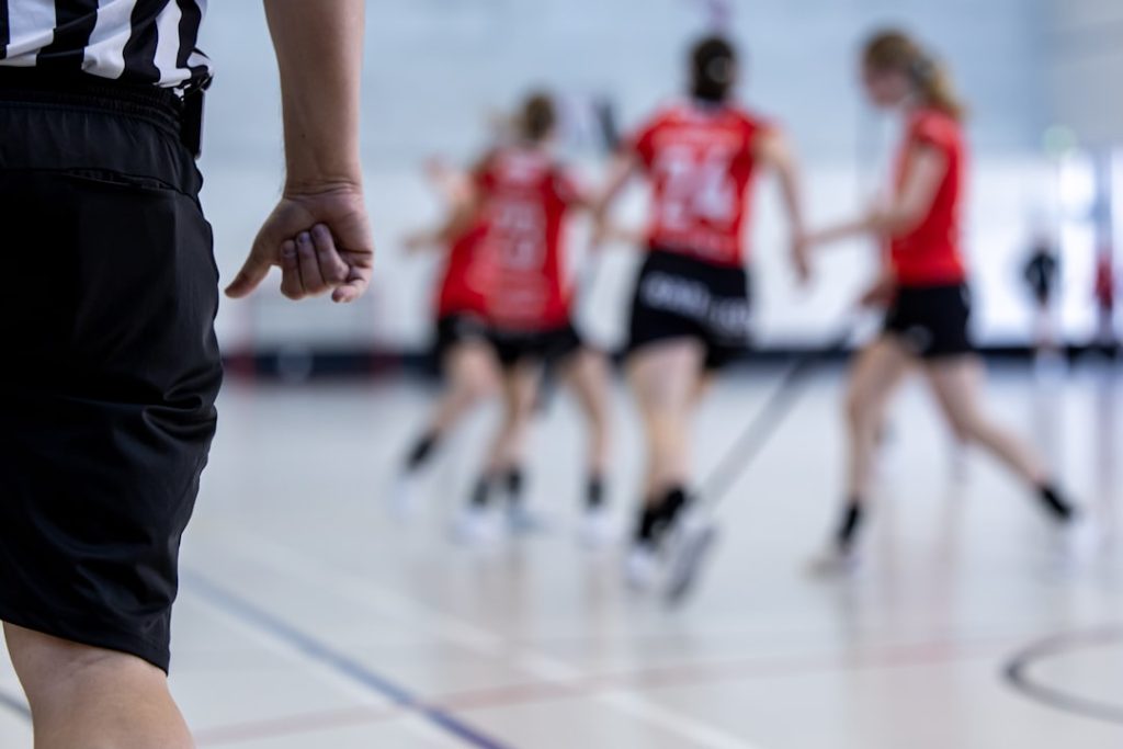 A referee watches a floorball game.