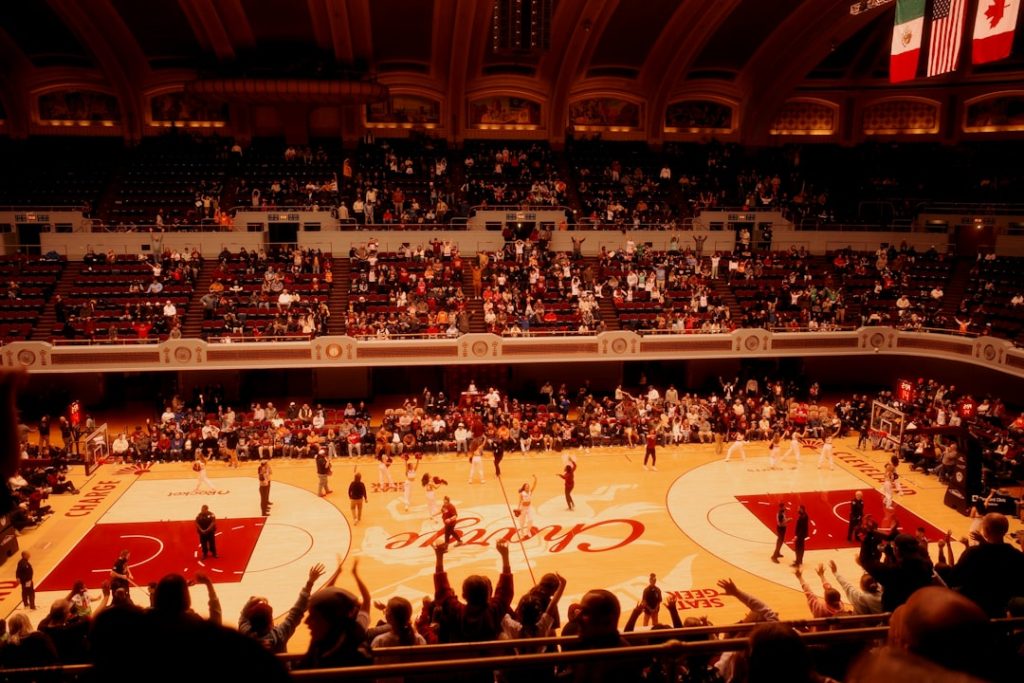 Basketball game in a packed arena with cheering crowd.