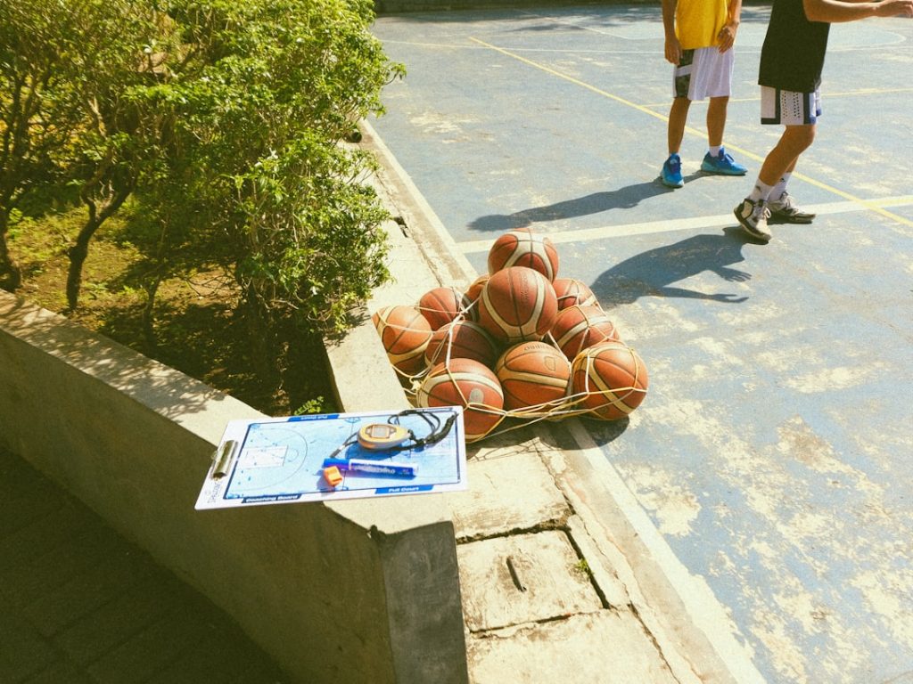 a pile of basketballs sitting on top of a basketball court