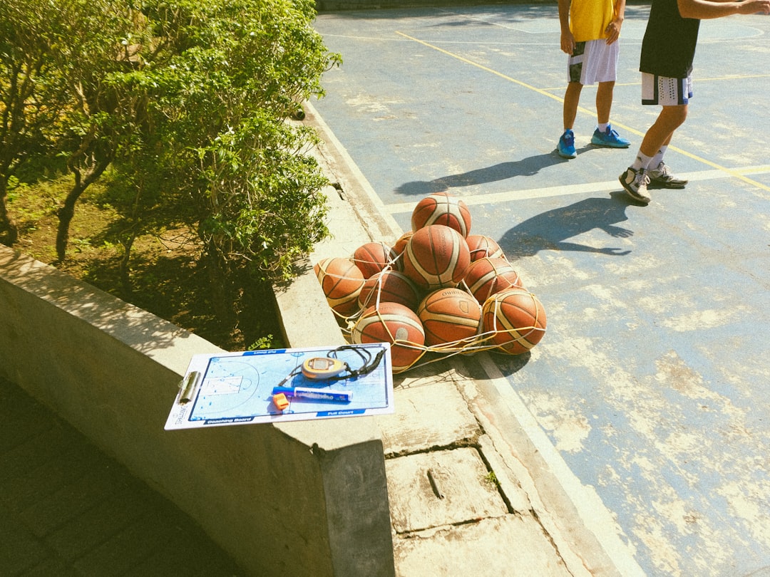 a pile of basketballs sitting on top of a basketball court