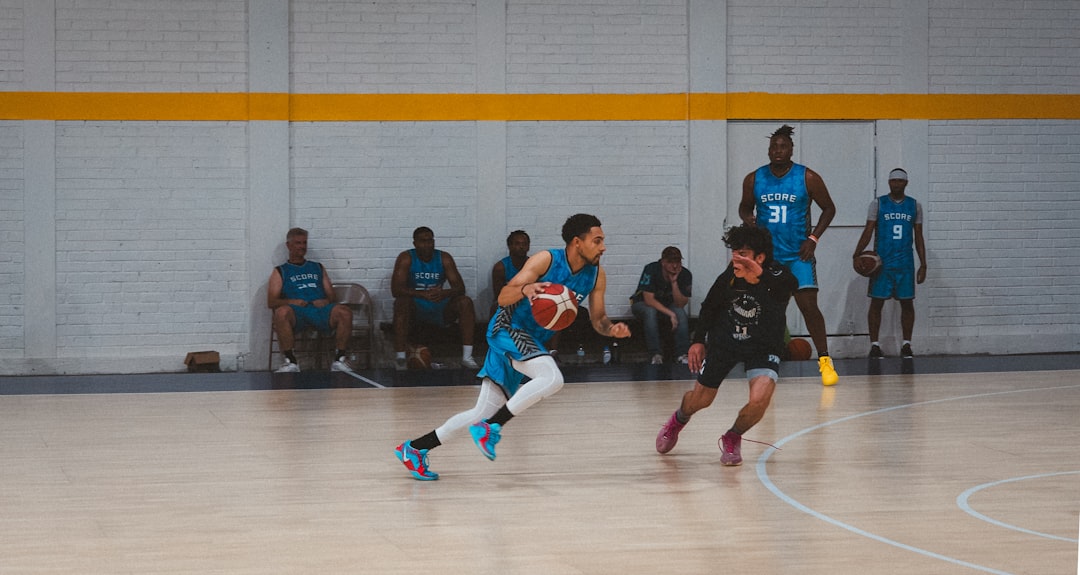 Basketball players dribbling on a court during a game.