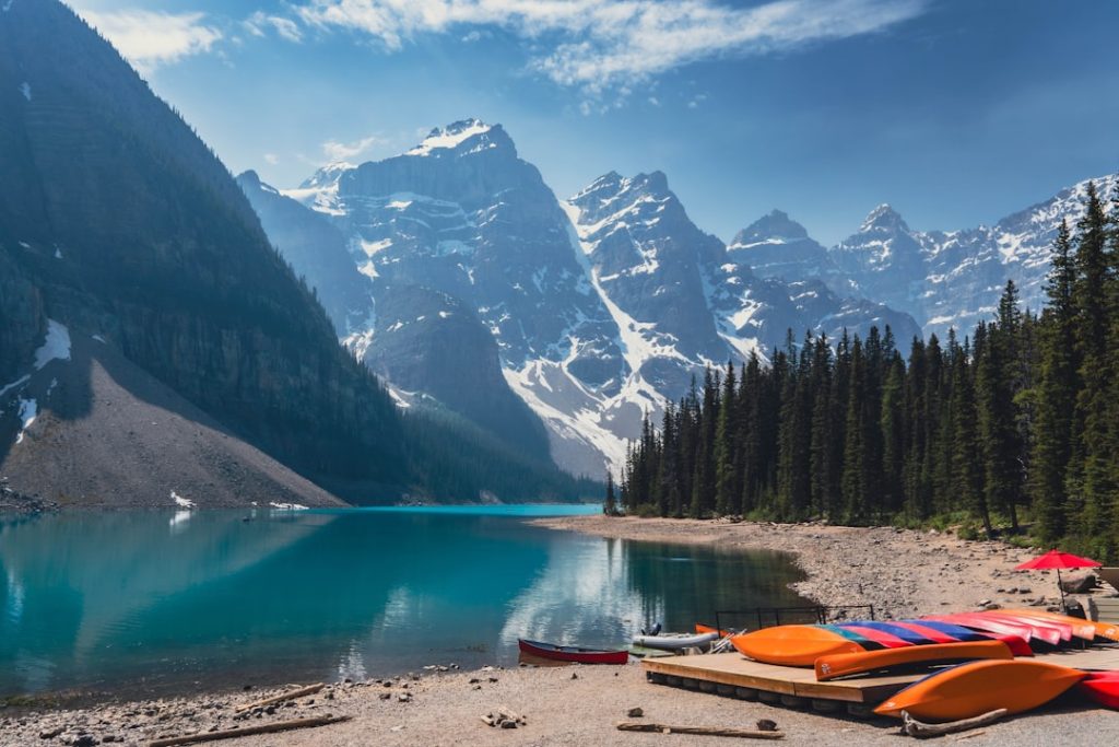 Turquoise lake with snow-capped mountains and pine trees