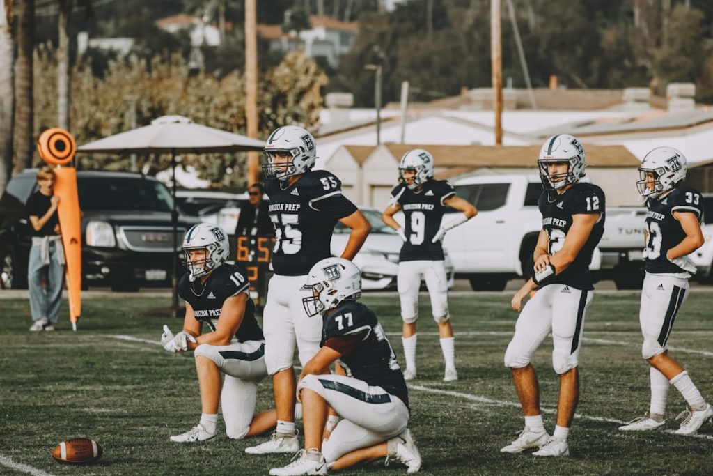 A group of football players standing on top of a field