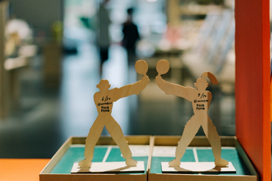 A pair of paper cutouts of two men playing tennis