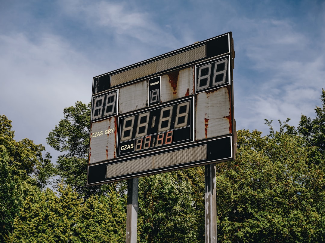 an old gas station sign with trees in the background
