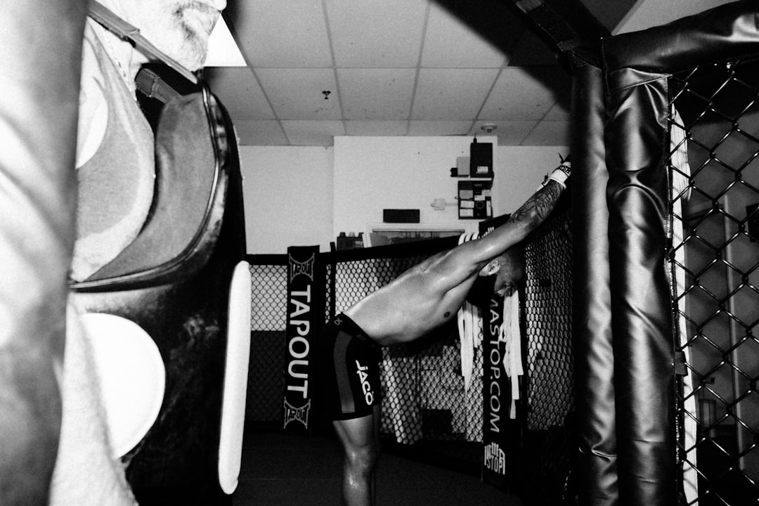 a man standing next to a punching bag in a boxing ring