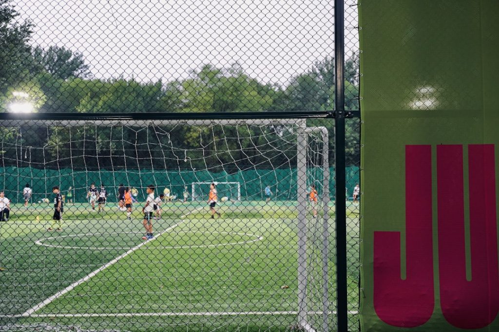 People playing soccer on a green field.