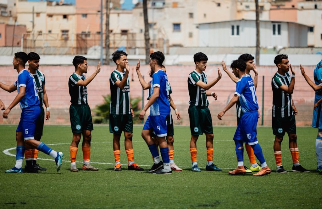 Soccer teams are shaking hands before a game.