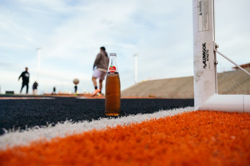a bottle of beer sitting on top of a field