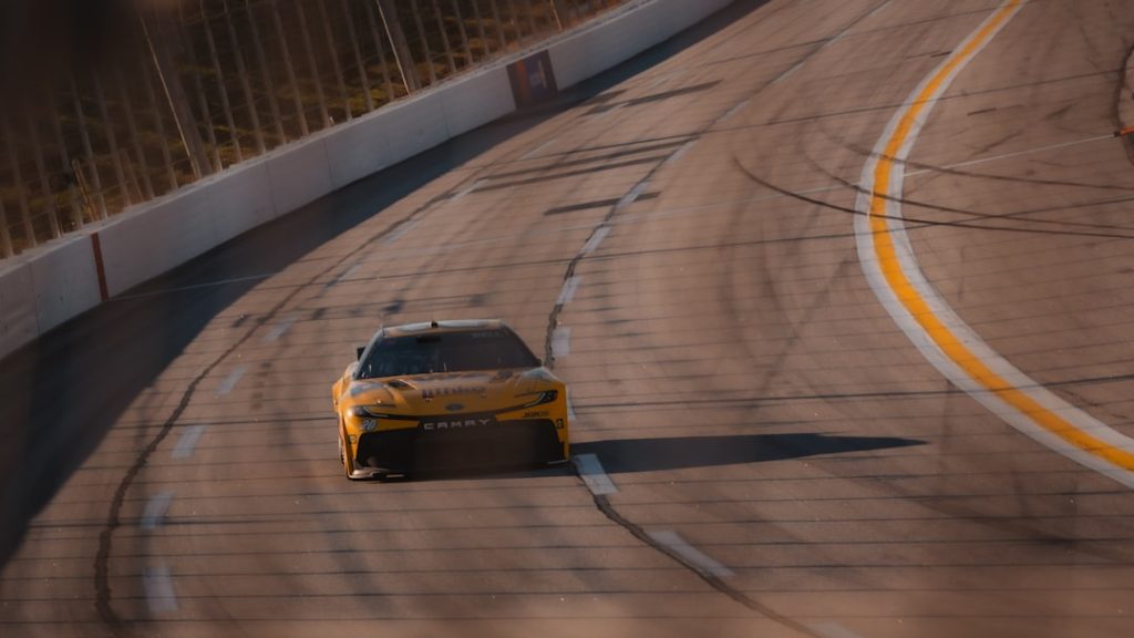 A yellow race car speeds around a track.