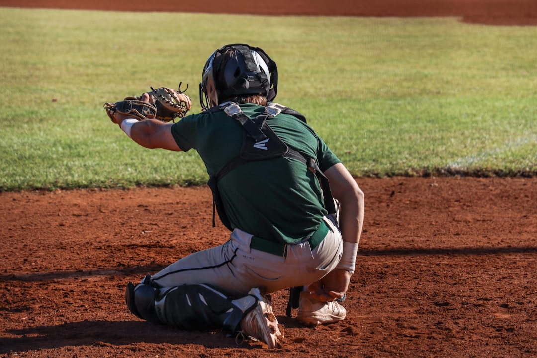 A baseball player kneeling on a baseball field