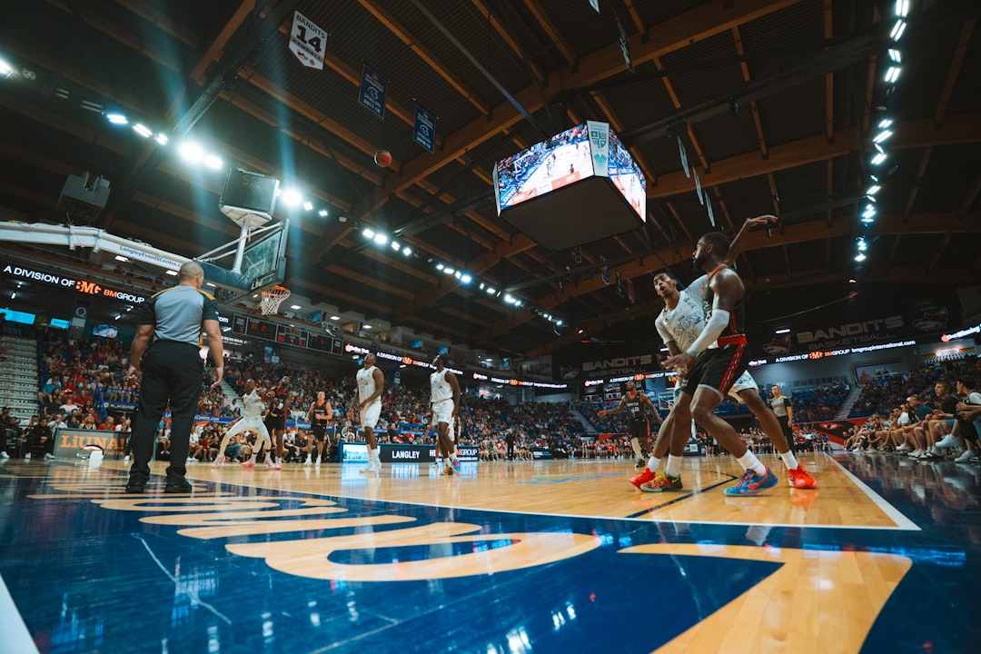 Basketball players are competing in a game inside an arena.