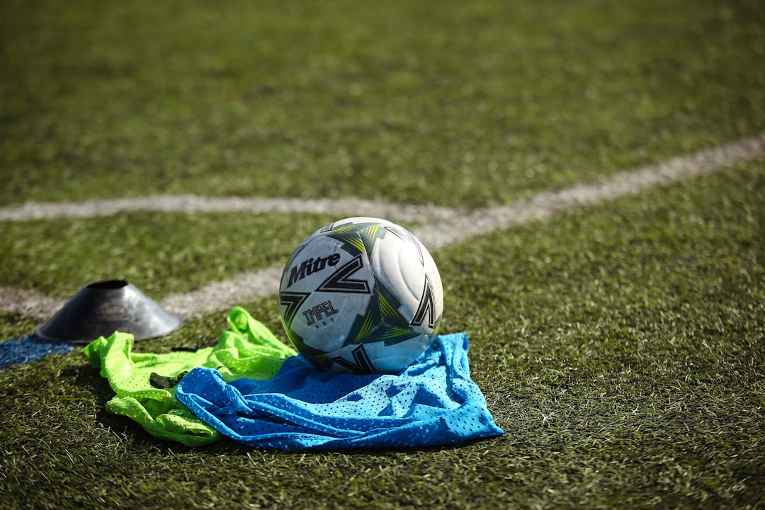 A soccer ball rests on a shirt in the grass.