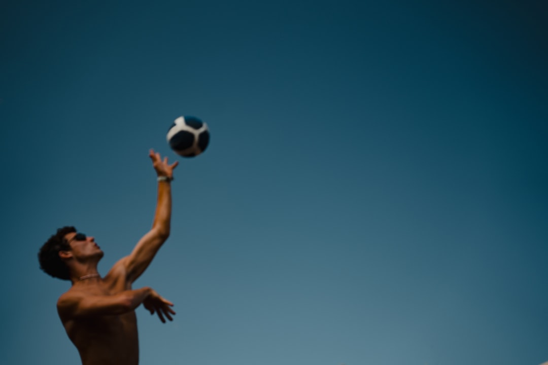 a man reaching up to catch a soccer ball