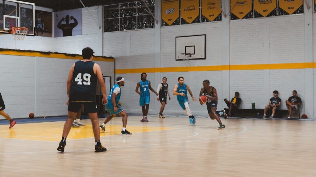 Basketball players compete on an indoor court.