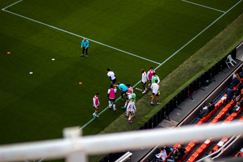 a group of people standing on top of a soccer field