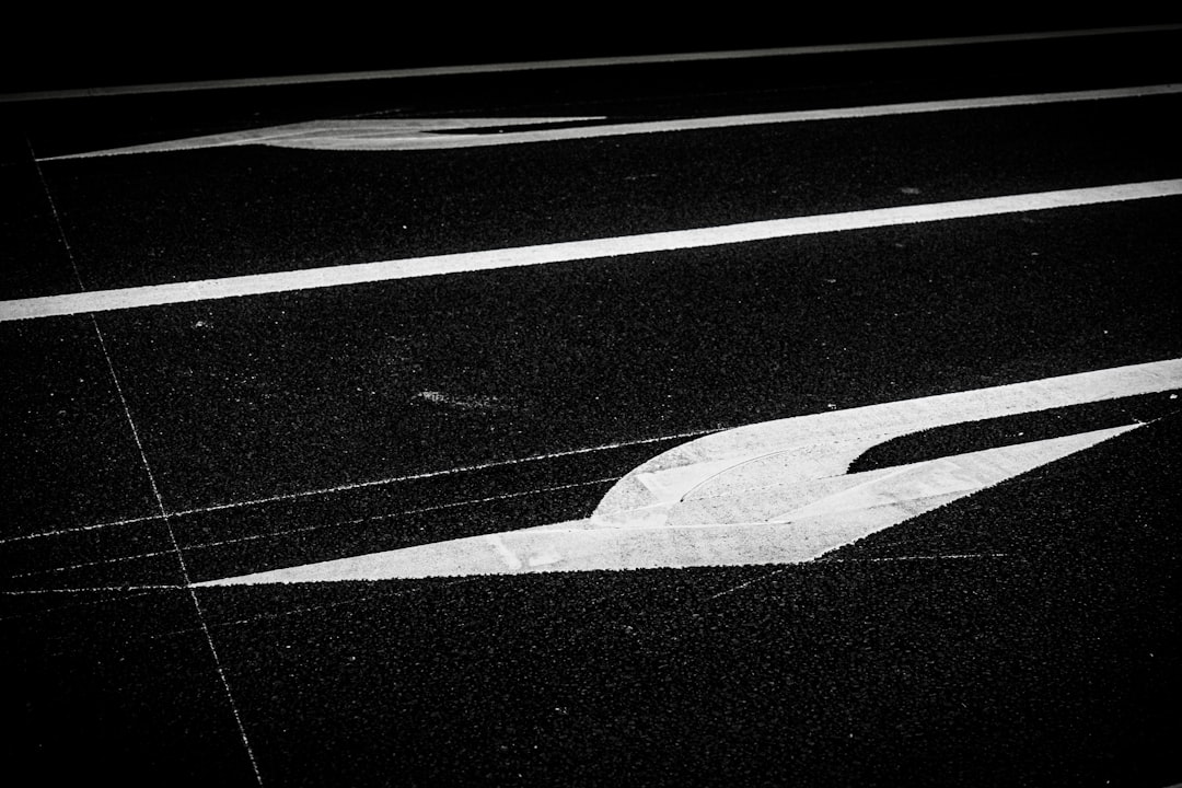 a road with a white arrow