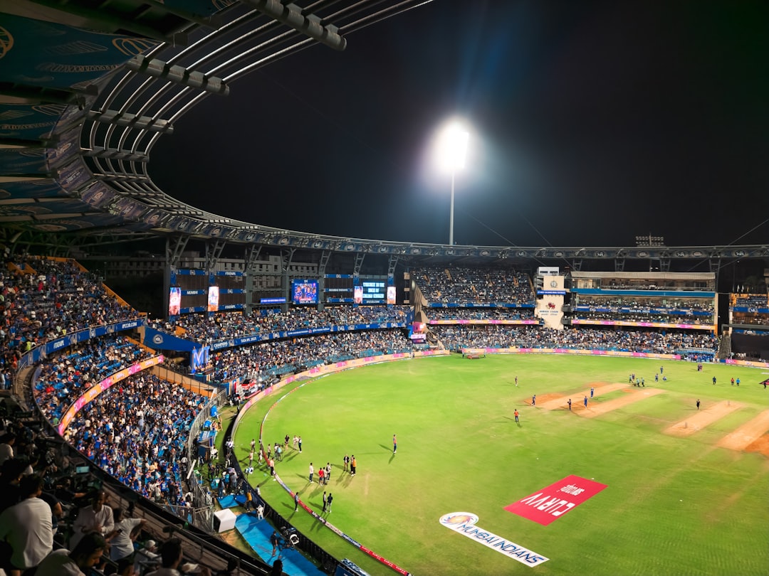 A cricket match is taking place in a stadium.