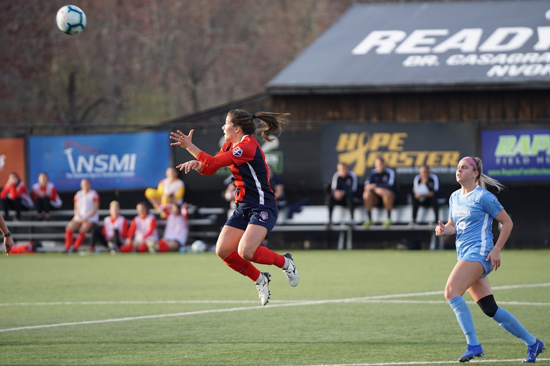 woman jumping about to catch soccer ball
