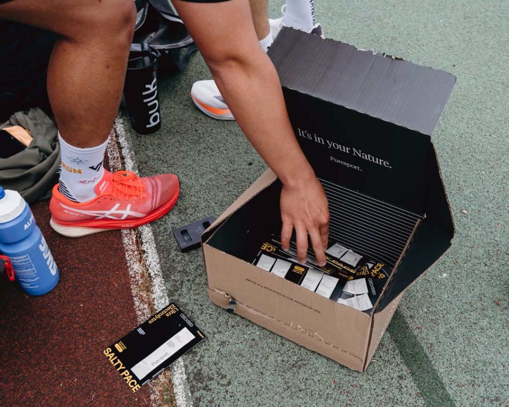 Someone reaching into a box of protein bars.