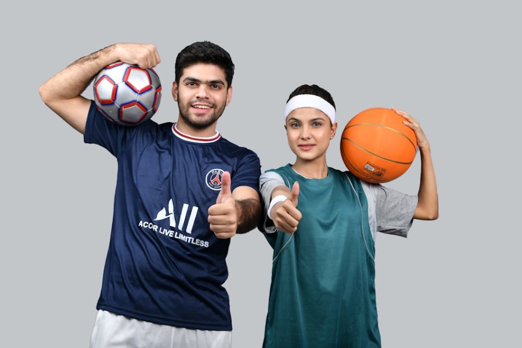 a man and a woman holding a basketball and posing for the camera