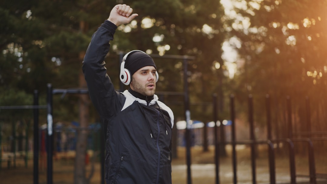 Man in headphones raises fist outdoors