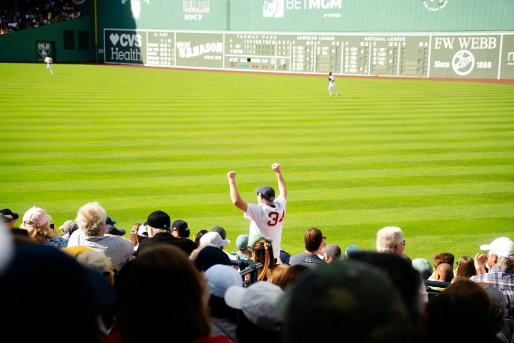 Baseball player celebrates on field with fans watching