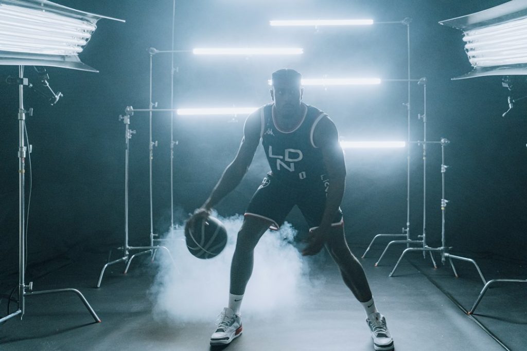 a man holding a basketball in a dark room
