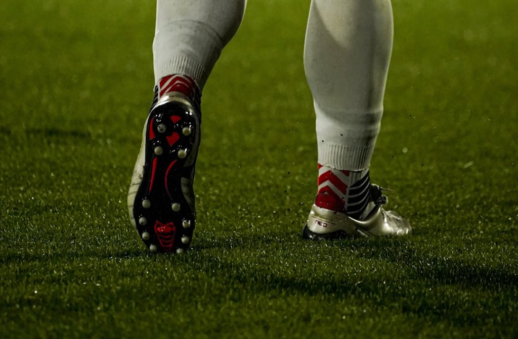 Football player's legs and cleats on the grass