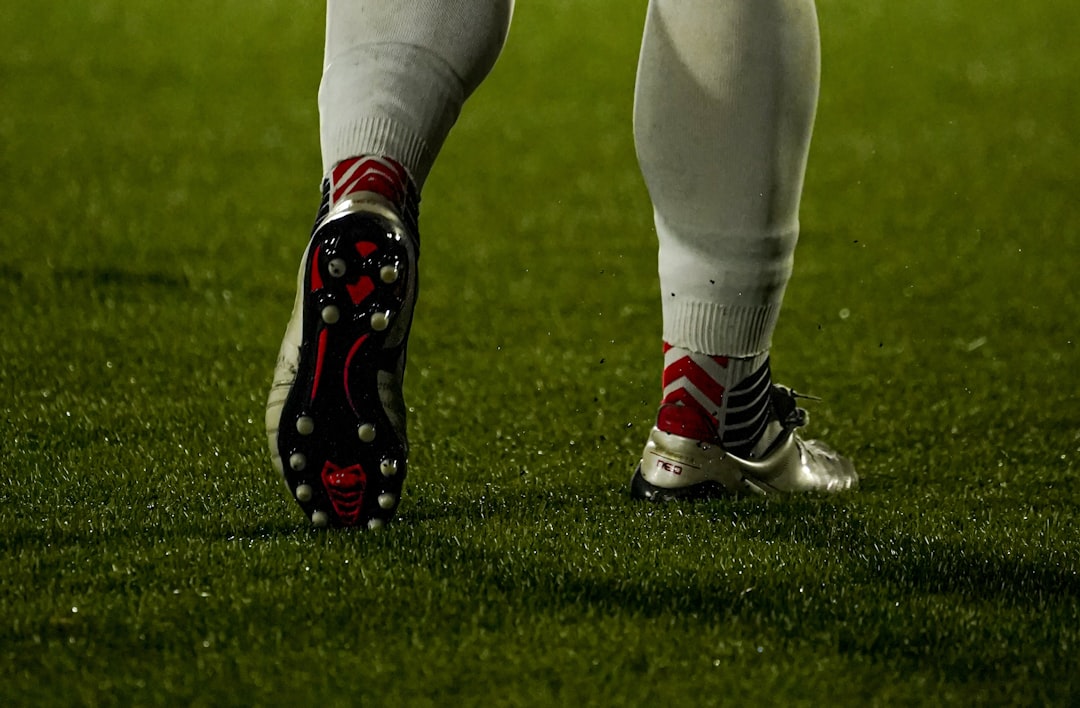 Football player's legs and cleats on the grass