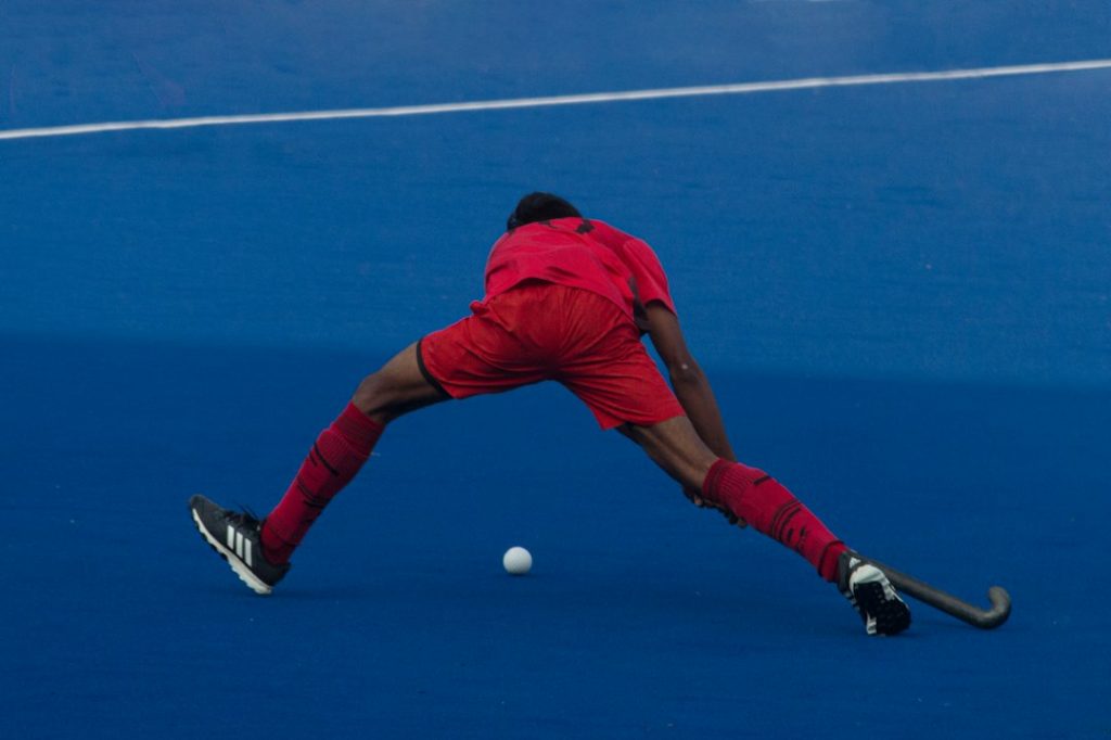 a man in a red uniform playing a game of hockey