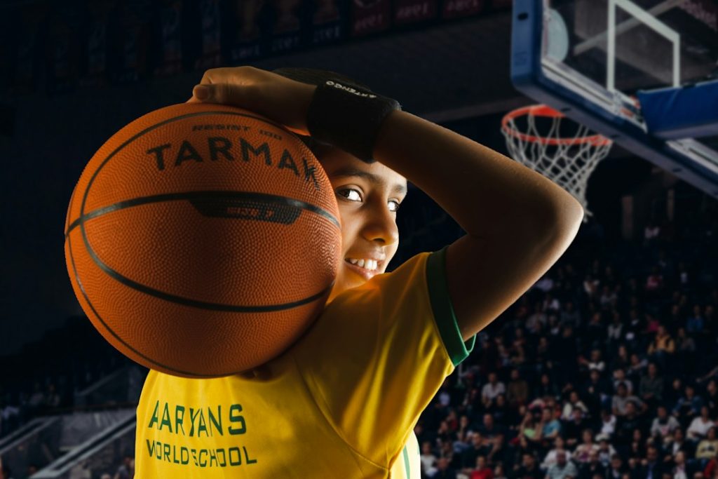 a young boy holding a basketball over his head