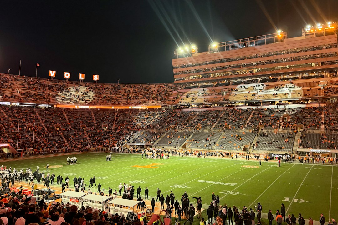 A crowded football stadium at night under bright lights