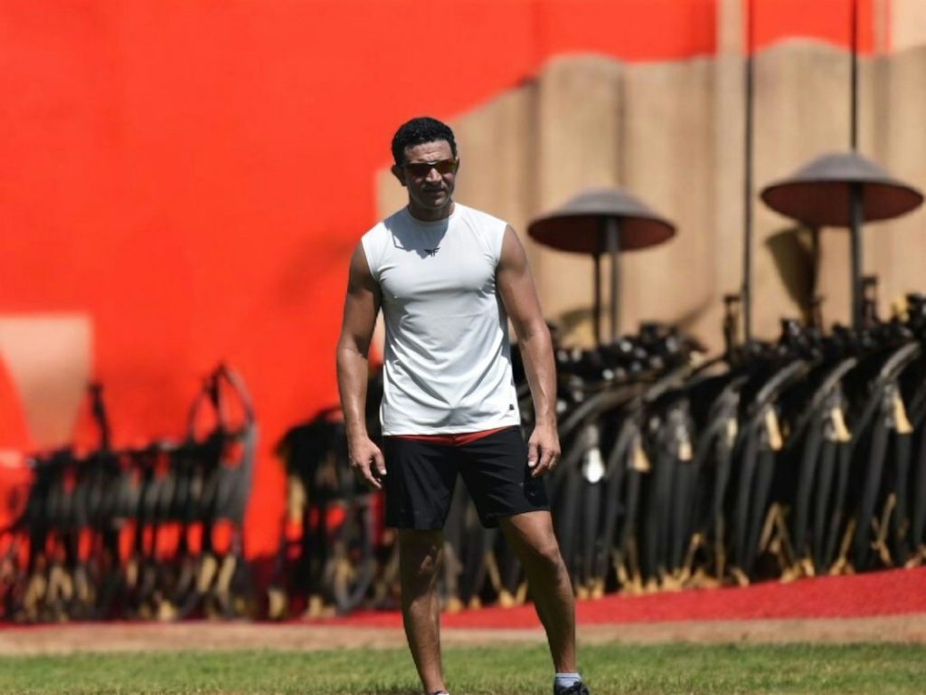 Man in athletic wear standing on grassy field