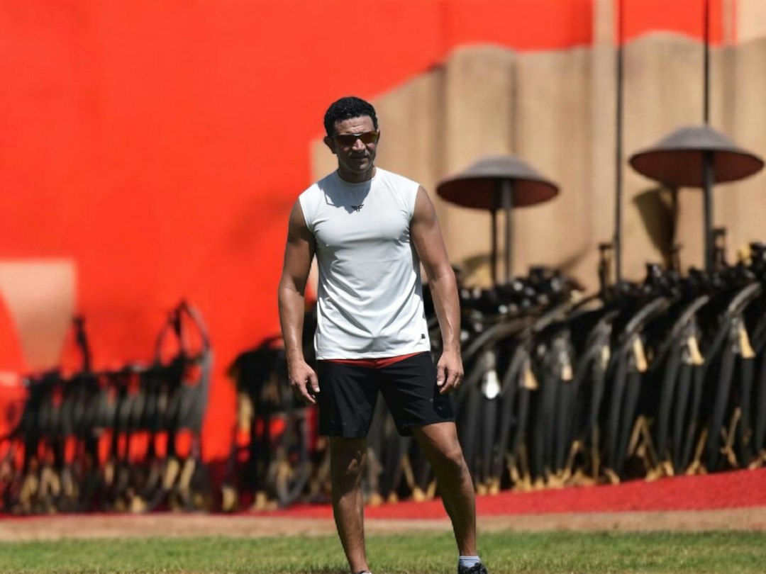 Man in athletic wear standing on grassy field