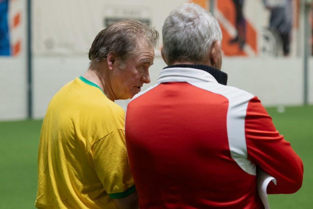 A couple of men standing next to each other on a field