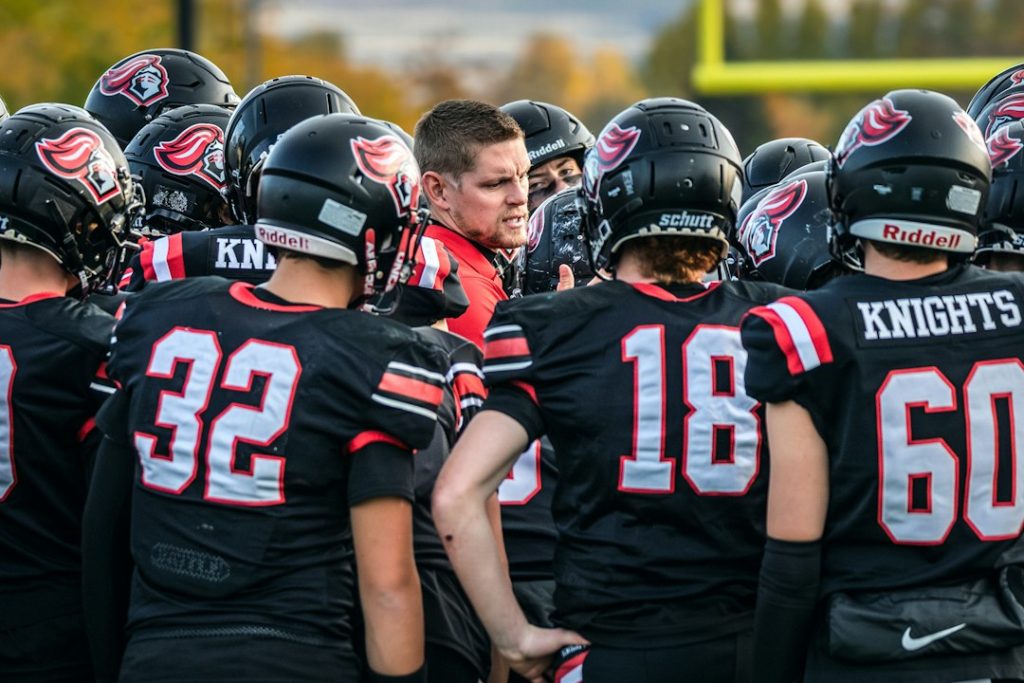 Football coach talking to players in huddle