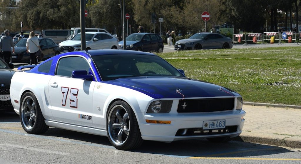 White and blue ford mustang with number 75 on side