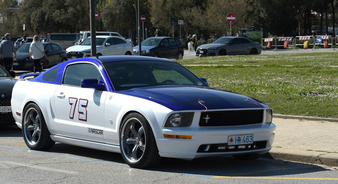 White and blue ford mustang with number 75 on side
