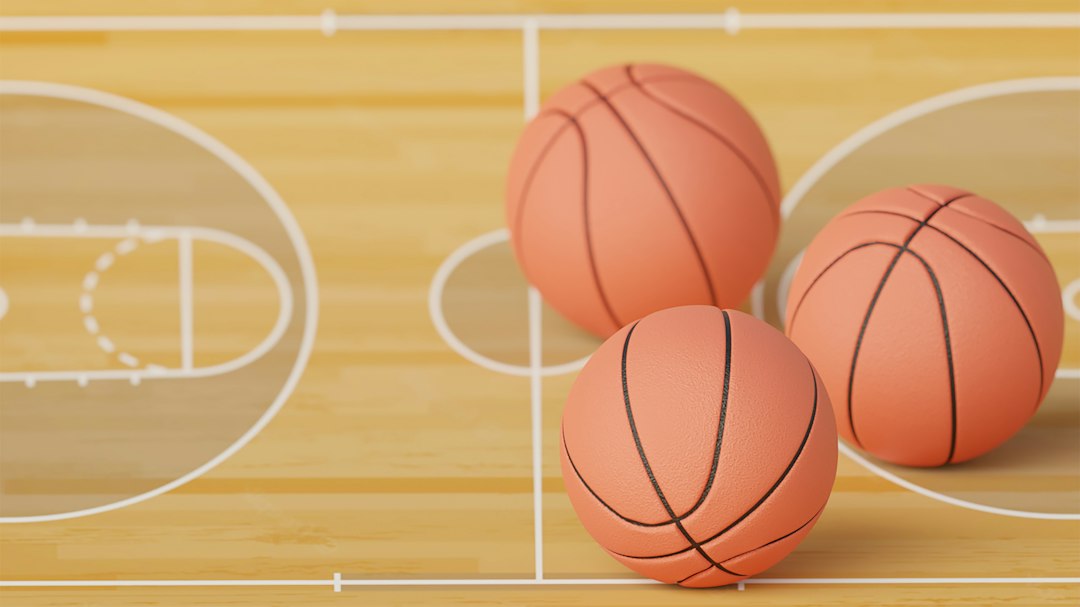 three basketballs sitting on top of a basketball court