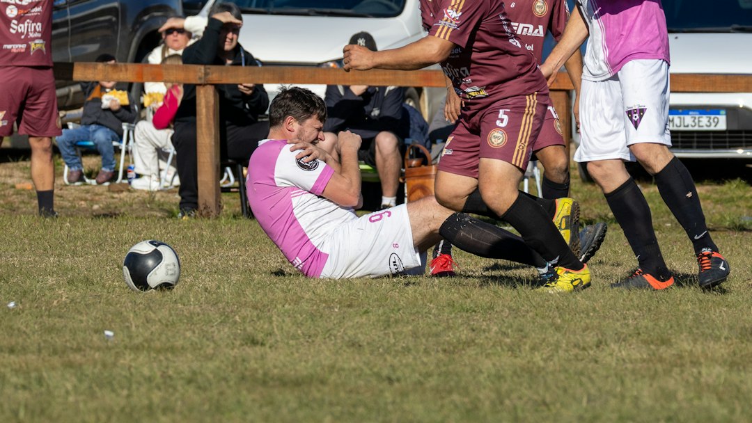 Player in pink uniform on ground during soccer match