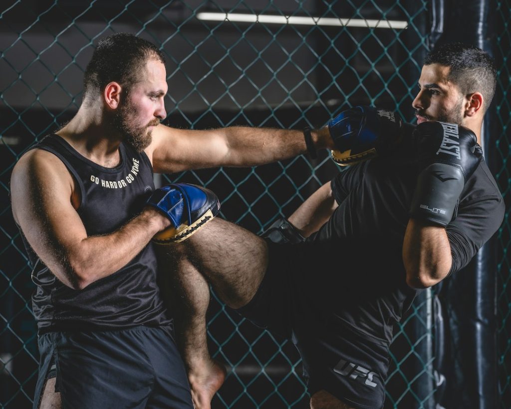 two men are fighting in a caged area