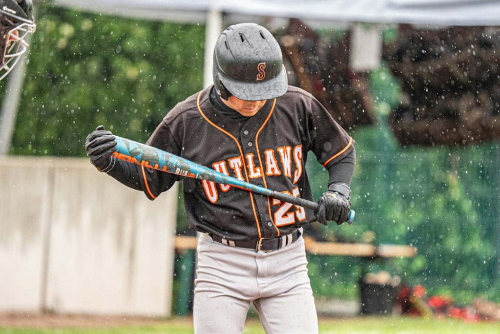 A baseball player gets ready to bat in the rain