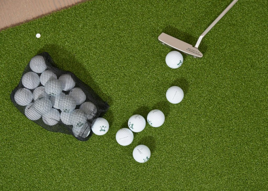 Golf balls spilling from a bag with a putter